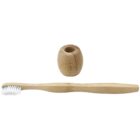 A bamboo toothbrush with white bristles is lying horizontally, accompanied by a matching bamboo holder standing upright. The holder has a smooth, rounded shape and an opening at the top to hold the toothbrush.