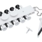 A white and black golf tee holder with attached chain holds several white and black tees. Two tees and one ball marker are placed beside the holder.