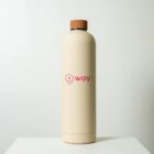 A beige insulated water bottle with a brown cap stands upright on a white surface. The bottle features a pink logo and the word way in pink on its side, set against a plain white background.
