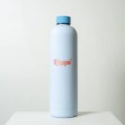 A tall, light blue bottle with a matching blue cap is set against a plain gray background. The bottle features the word Rappi in pink script font on its front.