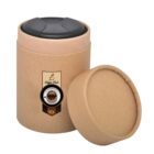 A brown cylindrical coffee canister with a black lid is shown with its lid slightly ajar and placed beside it. The canister has a logo featuring a coffee cup and the words Coffee Club.
