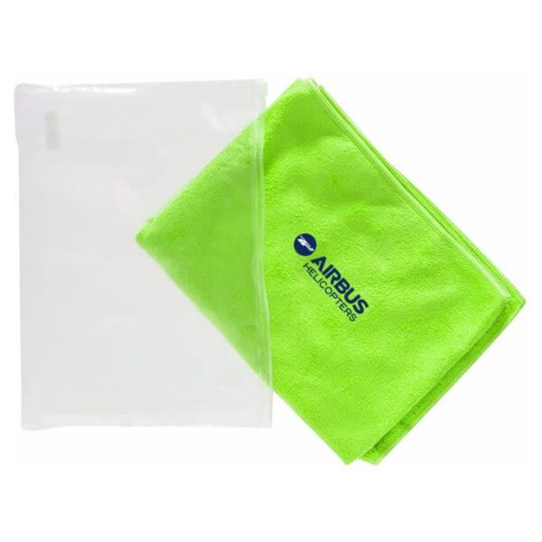 A bright green microfiber towel folded next to a transparent plastic pouch. The towel features a blue logo with the text AIRBUS HELICOPTERS.