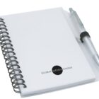 A spiral-bound notebook with Global Media Group logo on the cover, accompanied by a silver pen attached to the front. The notebook has a simple, professional design with a white cover.