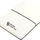 A closed white notebook with Central Clinic Inc and a logo printed on the cover. It is secured with a black elastic band, and a white ribbon bookmark is visible.
