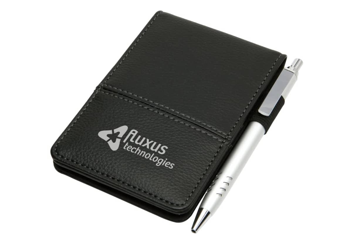 A small, black leather notepad with a silver pen attached on the side. The front cover features the Fluxus Technologies logo in white.
