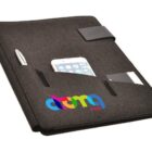 A black fabric organizer with multiple pockets, holding a silver pen, a smartphone, and small cards. The organizer has a colorful logo with the text atma.com on the front.