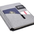 A grey fabric travel wallet with a Star Invest logo. It has a slot containing a passport and two cards, one white and one red. The design is sleek and organized, ideal for keeping travel documents secure.