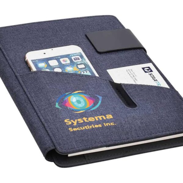 A navy blue notebook with a pocket holds a smartphone and a business card. The front is branded with a colorful eye logo and the text Systema Securities Inc. There is a black clasp on the right side.