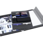 Open black portfolio with a notepad, three pens, earphones, and a section displaying promotional items like mugs and water bottles. The portfolio is spread on a flat surface.