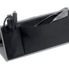 A black triangular desk organizer with pockets holds a pair of eyeglasses and a USB cable. The organizer has a sleek design with a sturdy base, suitable for holding small items and accessories.