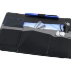 A black portfolio organizer with gray pockets holds a smartphone, blue pen, tablet, eyeglasses, USB cables, and white earphones. The organizer is neatly arranged on a white background.
