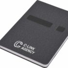 A dark gray notebook with the C-Link Agency logo on the cover. It has an elastic band for closure and a ribbon bookmark. The notebook is closed and resting at a slight angle.