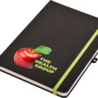 Black notebook with a green elastic band and a cover design featuring a red apple and the text The Health Group.