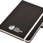 A black notebook with a white elastic band and a ribbon bookmark. The cover has a white logo and the text Estate Development Company printed on it.