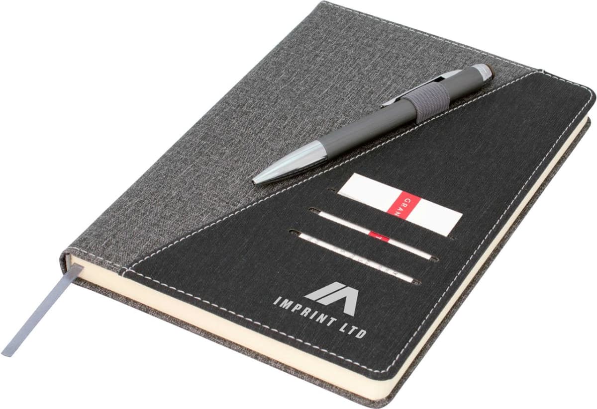 A gray notebook with a cloth cover, featuring a black diagonal section with three card slots, a pen holder, and a pen. The logo IMPRINT LTD is printed on the black section, and a gray ribbon bookmark is visible.