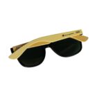 Foldable sunglasses with black lenses and wooden arms are laid flat. The brand name Champion is visible on the arms.