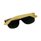Sunglasses with dark lenses and bamboo-like wooden arms are folded and placed upside down, showing the unique curved design of the arms resting on the lenses.