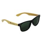 Stylish sunglasses with black frames and dark lenses. The arms are light-colored, featuring the Champion logo in black and red.