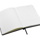 An open lined notebook with a black cover, displaying two blank pages. A black ribbon bookmark is visible, placed in the center. The pages have lines for writing and small spaces for dates at the top.