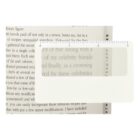 A magnifying ruler placed over a page from a book, enlarging the text beneath it. The ruler has measurement markings from 0 to 3 inches, with a rectangular lens in the center to magnify the text.