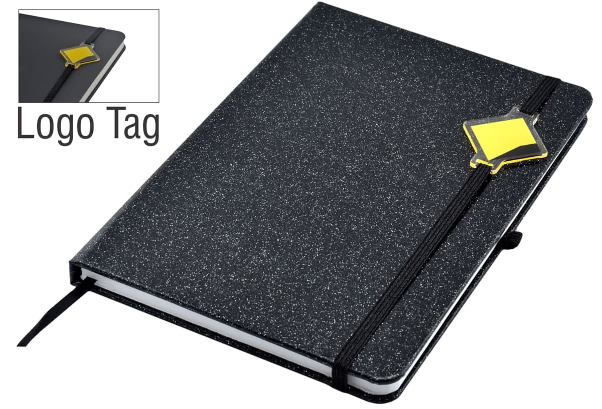A black sparkly notebook with a black elastic band and a yellow diamond-shaped logo tag on the cover. The notebook is closed, and theres a ribbon marker. An inset shows a close-up of the logo tag.