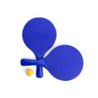 Two blue ping pong paddles crossed over each other with a yellow ping pong ball placed beside them, all set against a plain white background.