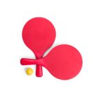 Two red table tennis paddles crossed over each other with a yellow ball placed below them on a white background.