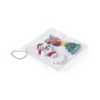 A transparent pouch with a chain contains festive erasers: a snowman, a reindeer, a Christmas tree, and Santa Claus. The erasers are colorful and arranged inside the pouch on a white background.