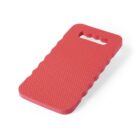 Red foam kneeling pad with a textured surface and a handle cutout at one end. The edges are scalloped for grip. The shape is rectangular with rounded corners.