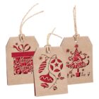 Three rustic gift tags with festive designs cut out. One has Merry Christmas with a present, another shows hanging baubles, and the third features a Christmas tree. Each tag has a twisted string attached.