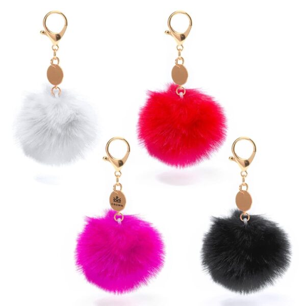 Four fluffy pom-pom keychains in white, red, pink, and black are displayed. Each has a gold-colored clasp and a round tag. The pom-poms are soft and spherical, creating a vibrant and playful assortment.