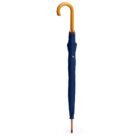 A closed blue umbrella with a curved wooden handle stands upright. The fabric is neatly wrapped, and the tip rests on a white surface.