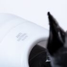 Close-up of a white antibacterial object with a smooth surface, featuring engraved text ANTI BACTERIAL ISO22196. A blurred dark element is visible in the foreground on the right side.