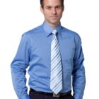 A man wearing a light blue shirt and a blue and white striped tie, standing with one hand in his pocket against a plain white background.