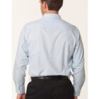 A person with short hair is standing with their back to the camera, wearing a light blue dress shirt and black pants.