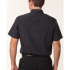 A person is standing with their back to the camera, wearing a black short-sleeve shirt with thin white vertical stripes and black pants. The background is plain and light-colored.