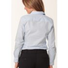 A person with long hair is shown from behind wearing a light blue collared shirt and black pants. They are standing against a plain white background.