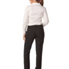 A woman stands with her back to the camera against a white background. She is wearing a white long-sleeved blouse, black dress pants, and black heels. Her brown hair is tied in a ponytail.