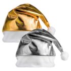 Two Santa hats with a metallic finish, one in gold and the other in silver. Both hats have white trim at the base and a white pom-pom at the tip.