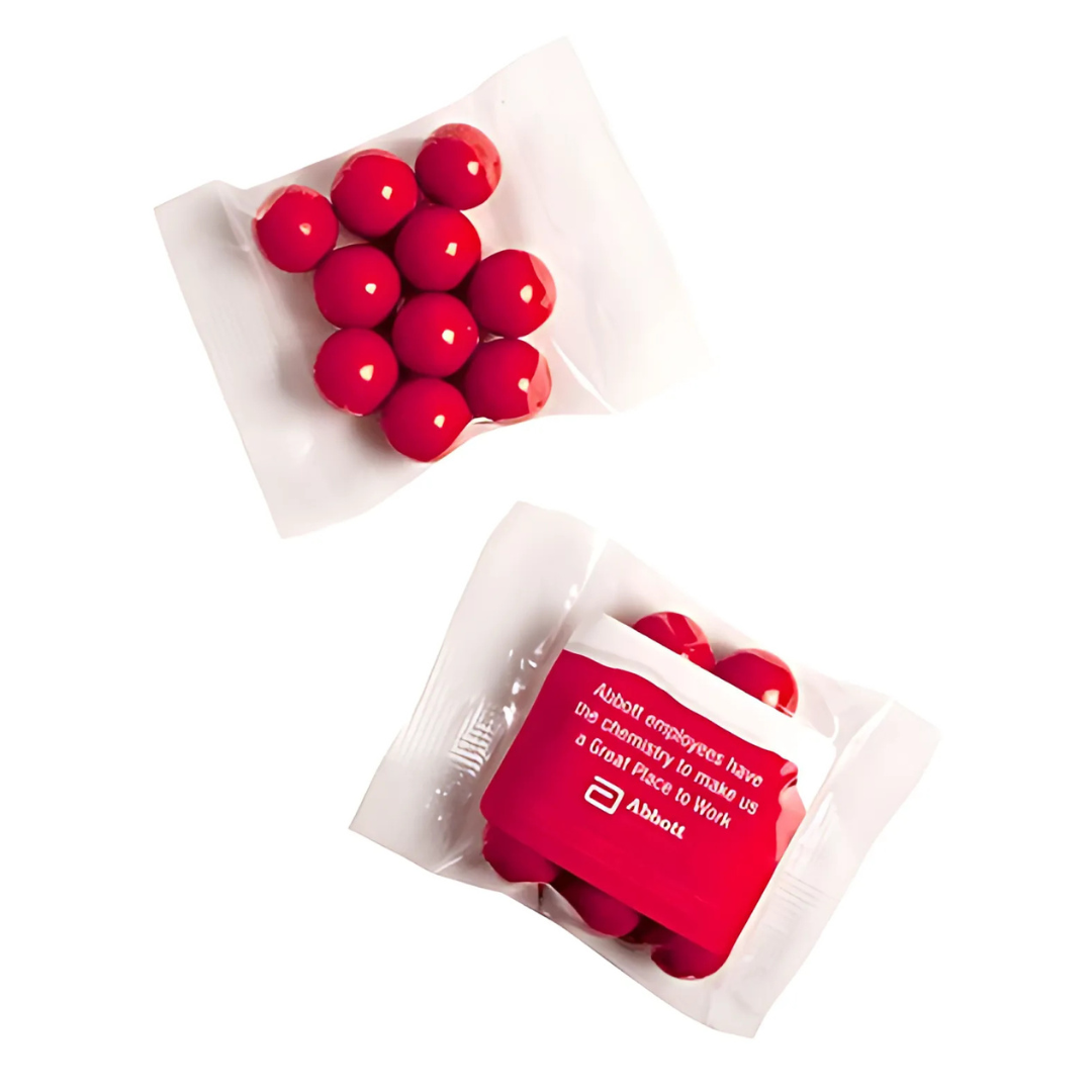 Two small, clear plastic bags containing 25g of red Jaffas each; one bag is open to show the candies, while the other remains sealed with a white-printed message about employees and a Mini Promotional Bags logo.