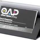 A smartphone is propped up by a sleek black stand, which also holds a business card for Offset Alpine Printing featuring the name Darryl Chappelow, Senior Sales Representative and an address in Lidcombe, NSW, Australia.