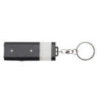 A black and white rectangular keychain light with a metallic ring attached. The device appears portable and functional, suitable for attaching to keys or a bag.