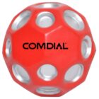 A spherical red toy with silver circular indents, featuring the word COMDIAL printed in black on its surface.