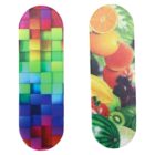 Two skateboard decks: one features a colorful grid pattern with various shades of green, blue, pink, and purple; the other showcases a vibrant collage of assorted fruits, including oranges, apples, grapes, and watermelon.