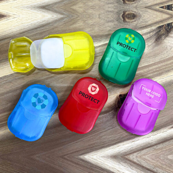Five colorful cases containing thin sheets are displayed on a wooden surface. The cases are yellow, green, red, blue, and purple, each with text or icons on them. The top yellow case is open, revealing the contents inside.