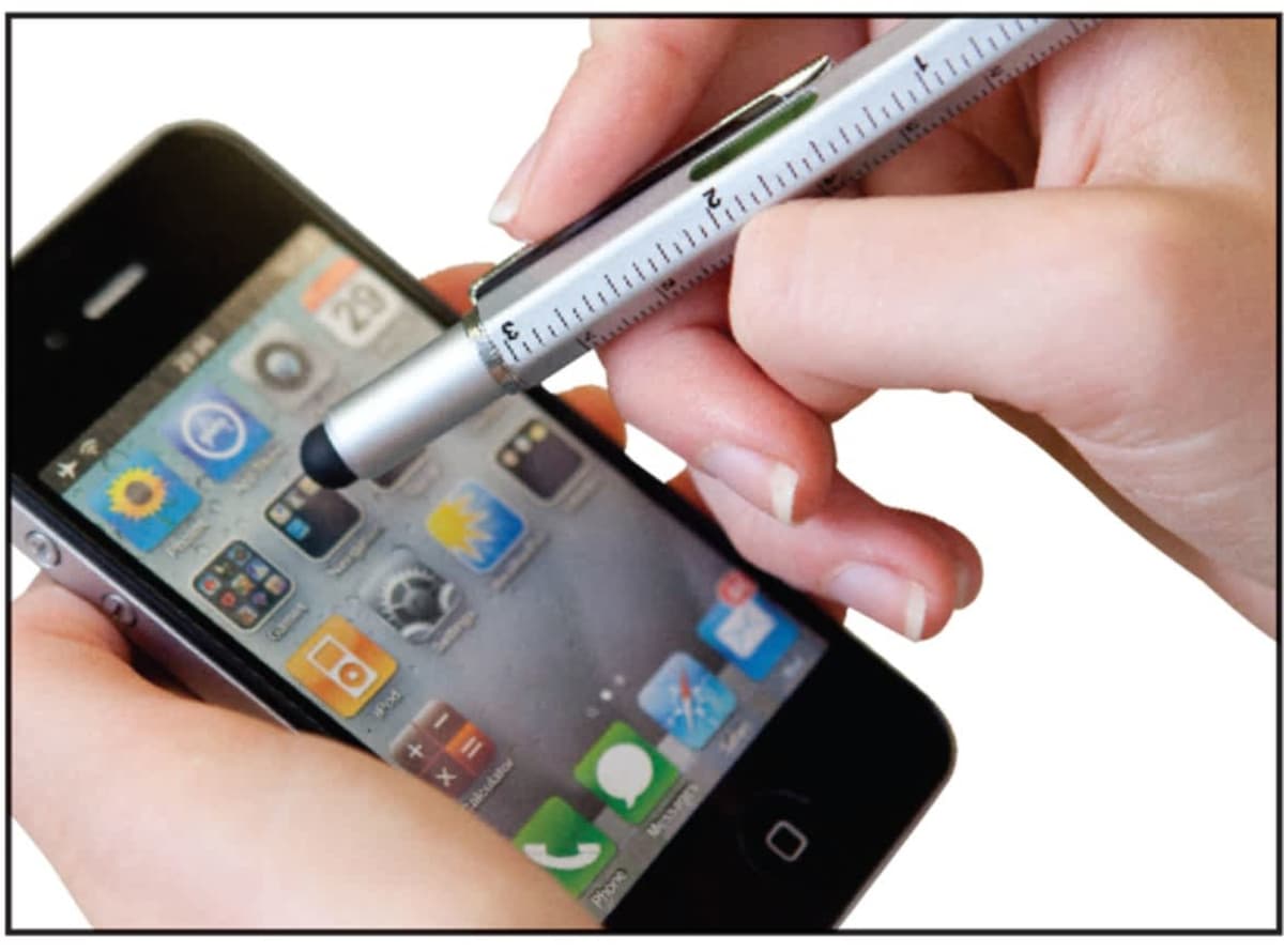 Close-up of hands holding a smartphone with apps on the screen, using a pen with a stylus tip to interact with the device.
