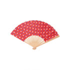 A red hand fan with a pattern of white stars, featuring a natural wooden base and ribs, displayed against a plain white background.
