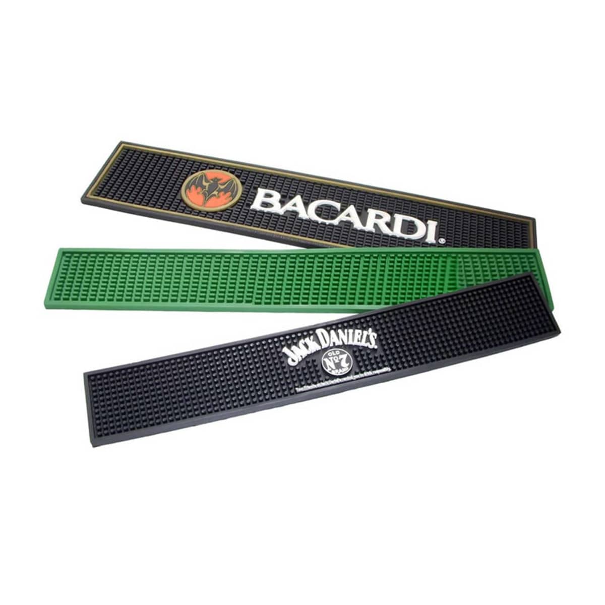 Three rubber bar mats are stacked. The top mat is black with a Bacardi logo, the middle mat is plain green, and the bottom mat is black with a Jack Daniels logo.