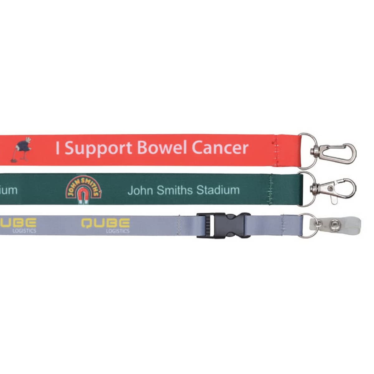 Three lanyards with clips: one red with I Support Bowel Cancer, one green with John Smiths Stadium and a logo, and one gray with Qube Logistics and a logo, featuring a plastic buckle.