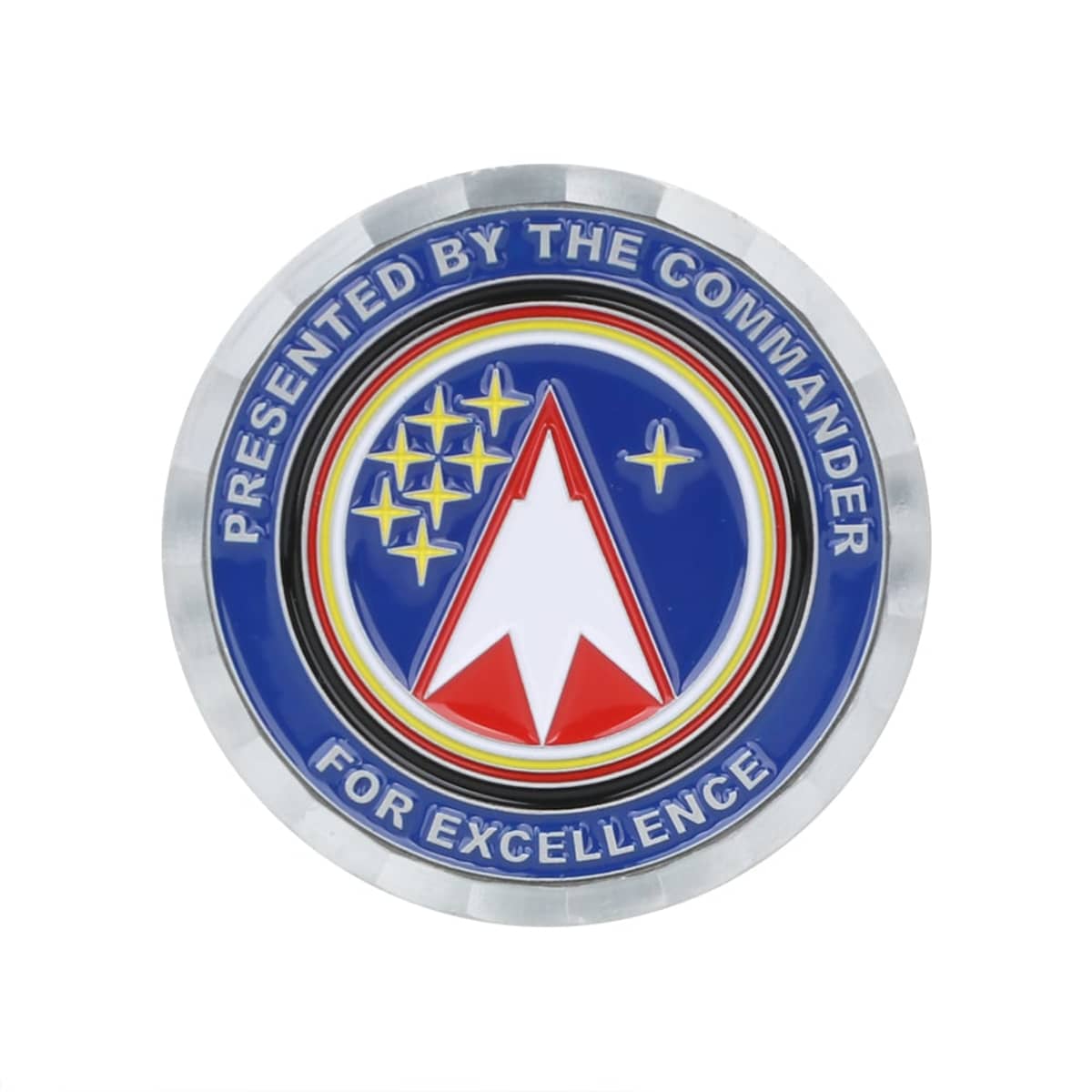 Circular emblem with the text Presented by the Commander for Excellence around the edge. Inside, a red, white, and blue design with stars and a rocket-like arrow pointing upwards against a blue background.